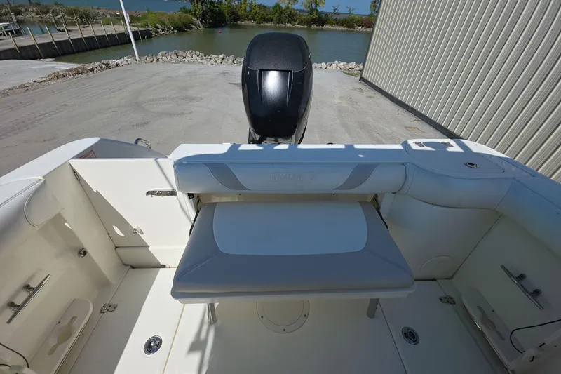 Slide: The Image of 2006 Boston Whaler 240 Outrage boat interior with seating and motor, dockside view. - 21