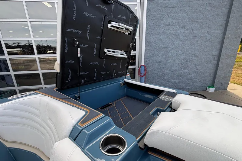 Slide: The Image of 2026 Tigé Ultré 25ZX boat interior with open storage compartment, white seating, and cup holder. - 20
