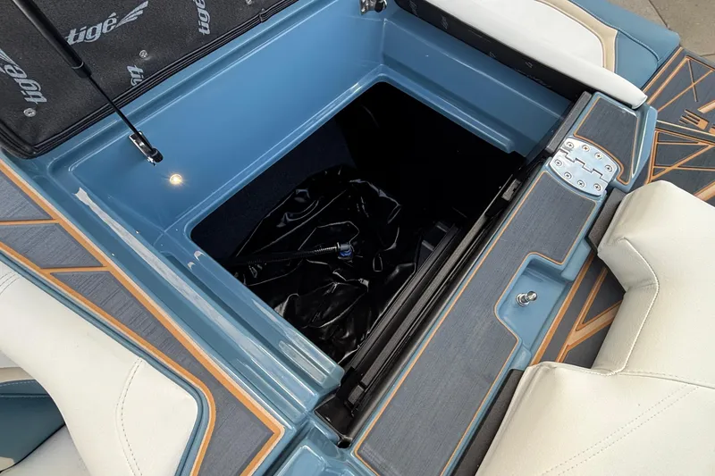 Slide: The Image of 2026 Tigé Ultré 25ZX boat storage compartment with stylish blue and white interior. - 22