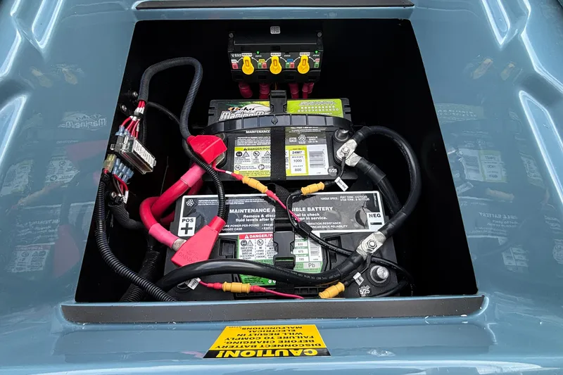 Slide: The Image of Battery compartment of 2026 Tigé Ultré 25ZX boat with wiring and caution label. - 57