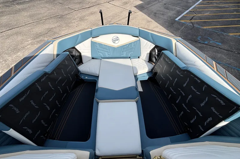Slide: The Image of 2026 Tigé Ultré 25ZX boat interior with blue and white seating, open storage compartments. - 60