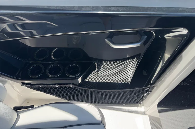 Slide: The Image of Interior of 2025 Yamaha AR250 boat with cup holders and storage net. - 19