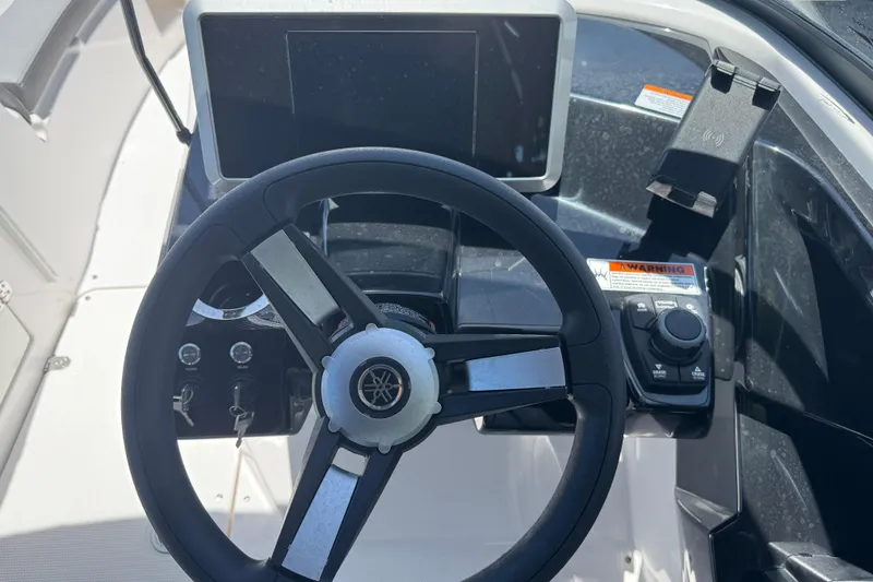 Slide: The Image of 2025 Yamaha Boats AR250 steering wheel and dashboard controls. - 22