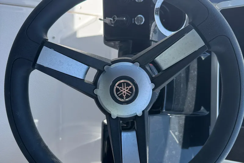 Slide: The Image of Steering wheel of 2025 Yamaha Boats AR250, showcasing sleek design and logo. - 25