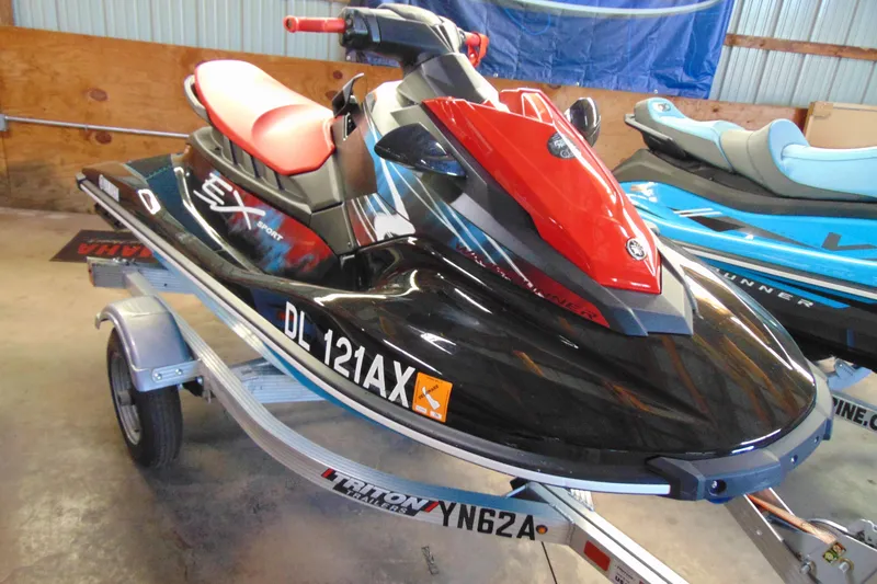 The Image of 2024 Yamaha WaveRunner EX Sport in showroom, black and red design on trailer. - 1