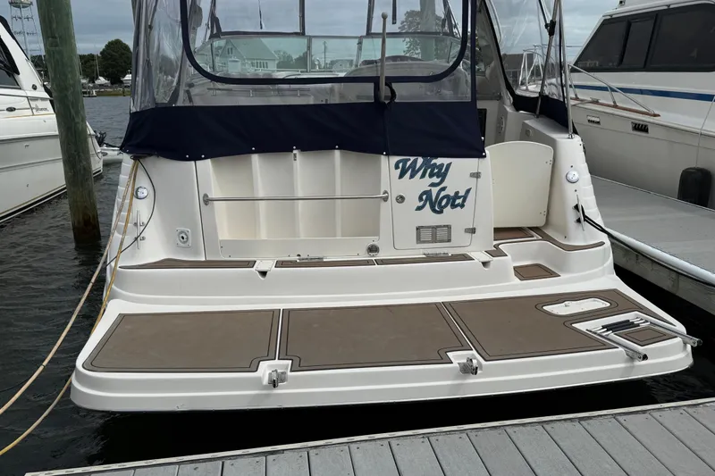 Slide: The Image of 2004 Rinker 342 boat docked, featuring "Why Not!" on the stern. - 14