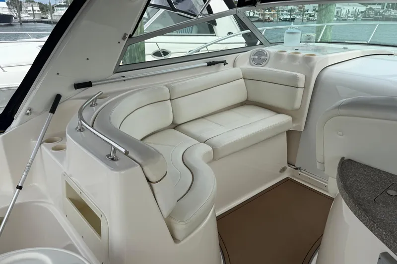 Slide: The Image of 2004 Rinker 342 boat interior with white leather seating and cup holders. - 15