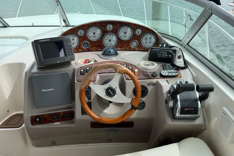 Slide: The Image of 2004 Rinker 342 boat dashboard with steering wheel and navigation instruments. - 16