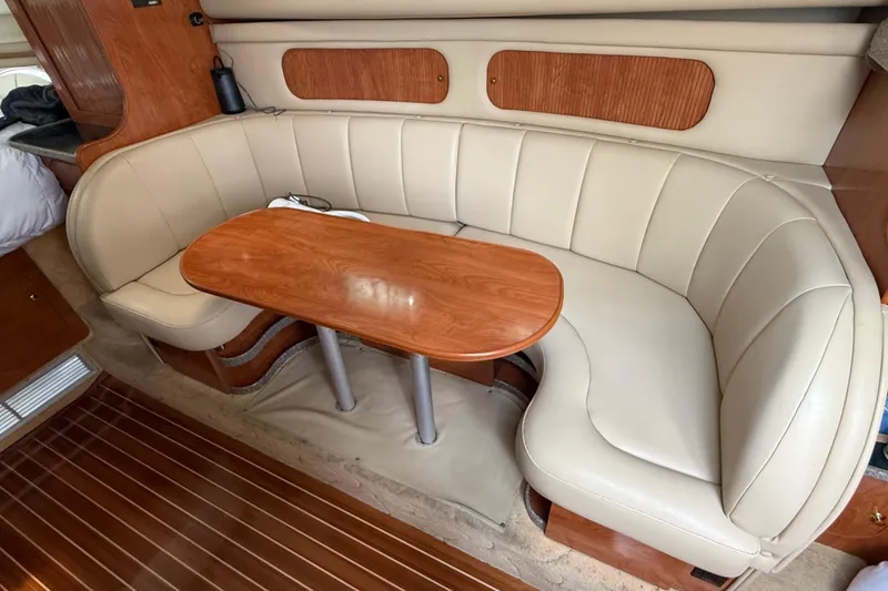 Slide: The Image of 2004 Rinker 342 yacht interior with beige leather seating and wooden table. - 6
