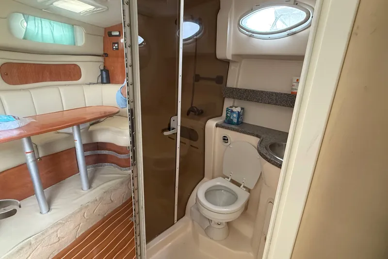 Slide: The Image of 2004 Rinker 342 boat interior with dining area and compact bathroom. - 8