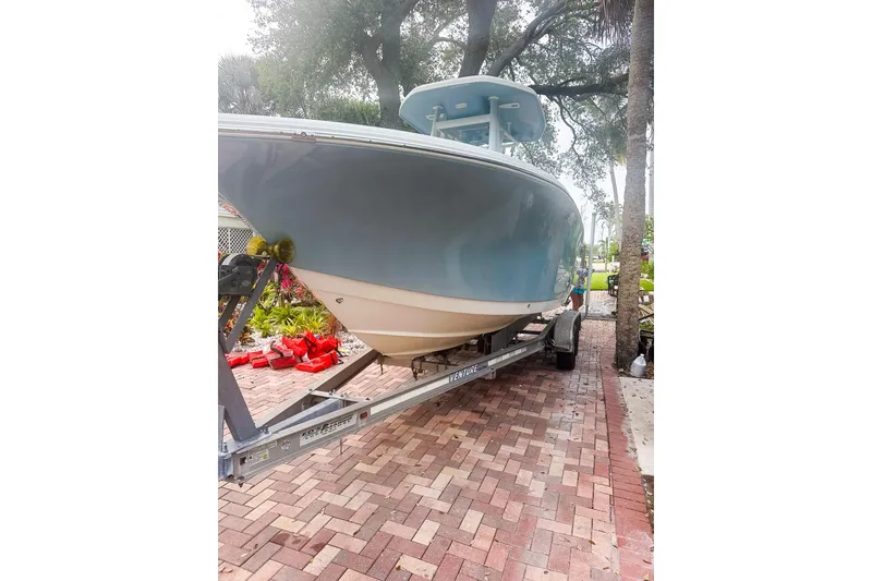 Slide: The Image of 2017 Tidewater 230 CC Adventure boat on trailer, parked on brick driveway. - 3