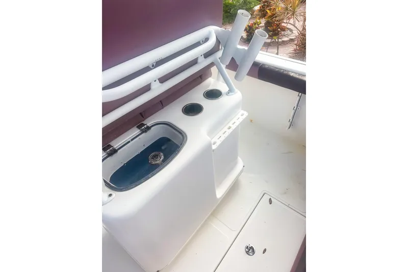 Slide: The Image of 2017 Tidewater 230 CC Adventure boat interior with rod holders and storage compartment. - 7
