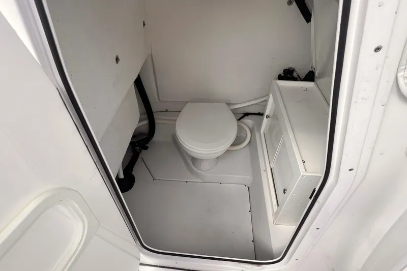 Slide: The Image of 2014 Sportsman Heritage 251 Center Console boat interior with compact marine toilet. - 8