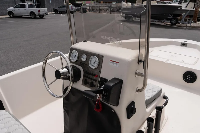 Slide: The Image of 2026 Carolina Skiff EV180 Sea Skiff boat console with steering wheel and gauges. - 9