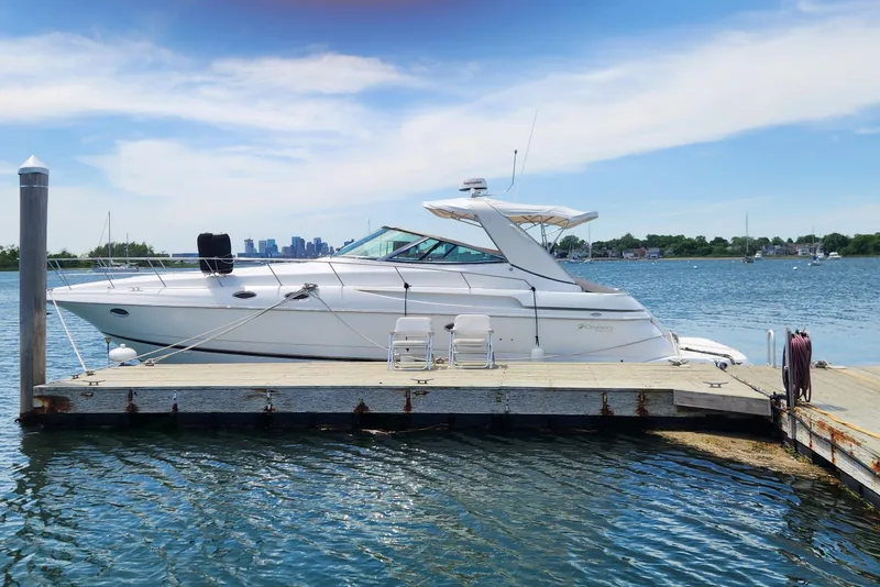 The Image of 2002 Cruisers Yachts 3870 Express docked on a sunny day, with city skyline in background. - 0