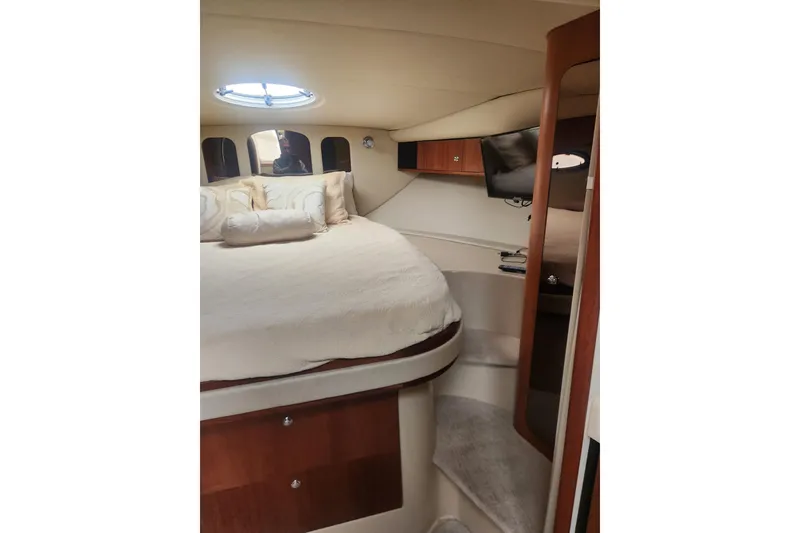 Slide: The Image of Interior of 2002 Cruisers Yachts 3870 Express with cozy bed and porthole window. - 11
