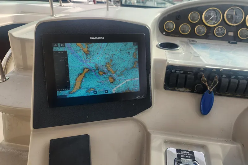 Slide: The Image of 2002 Cruisers Yachts 3870 Express dashboard with Raymarine navigation display and gauges. - 4