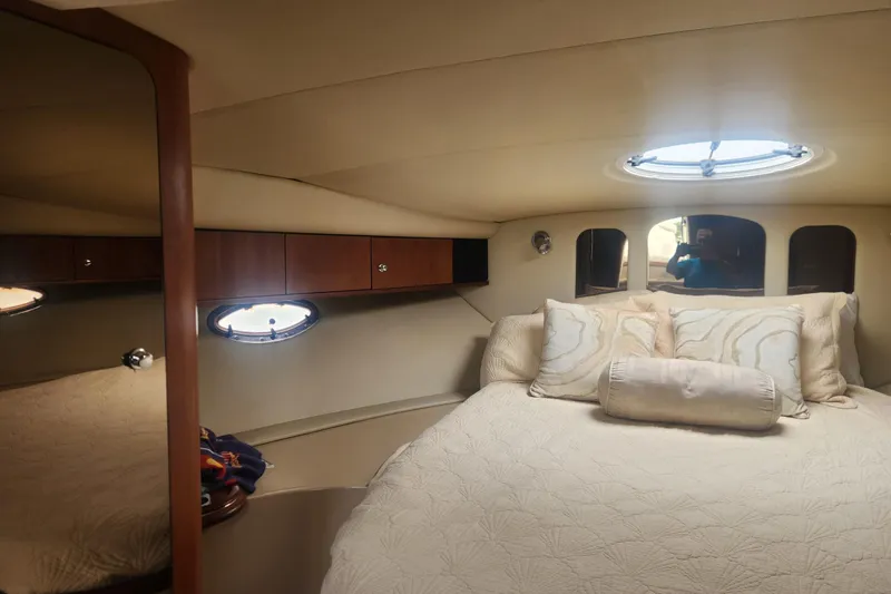Slide: The Image of Luxurious cabin interior of 2002 Cruisers Yachts 3870 Express with cozy bedding and porthole windows. - 10
