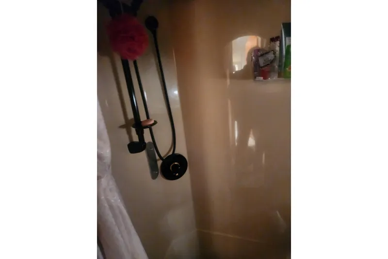 Slide: The Image of Shower area inside 2002 Cruisers Yachts 3870 Express, featuring modern fixtures and storage. - 17