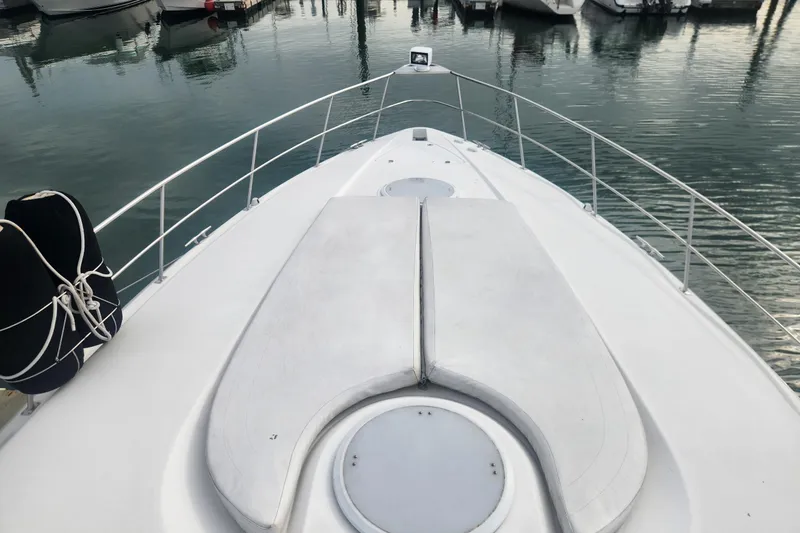 Slide: The Image of 2002 Cruisers Yachts 3870 Express boat deck at marina, featuring sleek design and railing. - 3