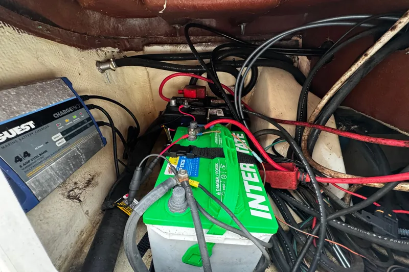 Slide: The Image of Battery compartment of 2019 NauticStar 22 XS Offshore with marine charger and wiring. - 17