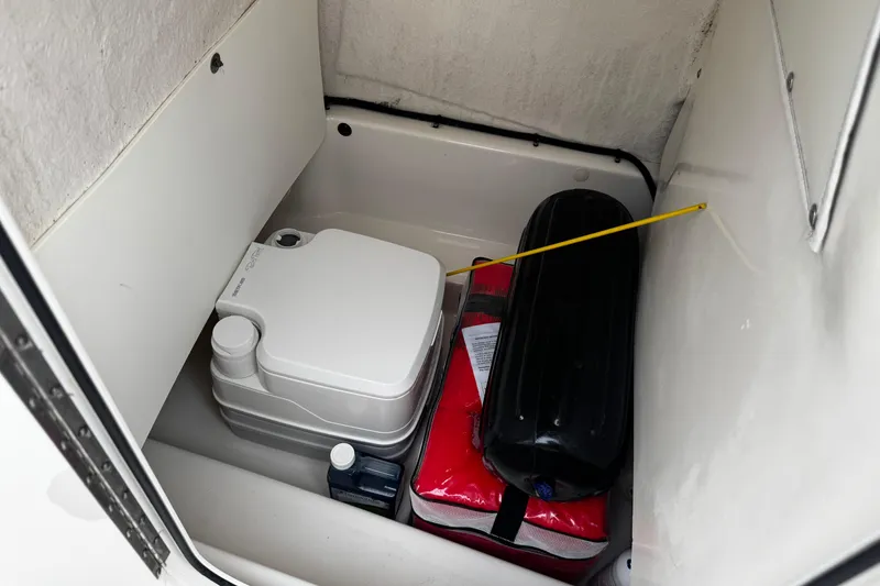 Slide: The Image of 2019 NauticStar 22 XS Offshore boat storage with portable toilet and safety equipment. - 26
