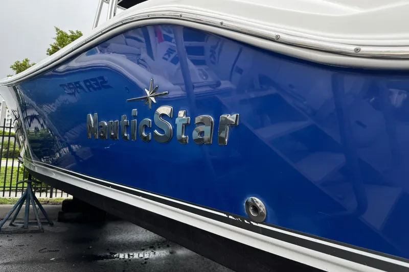 Slide: The Image of 2019 NauticStar 22 XS Offshore boat with blue hull and logo. - 35