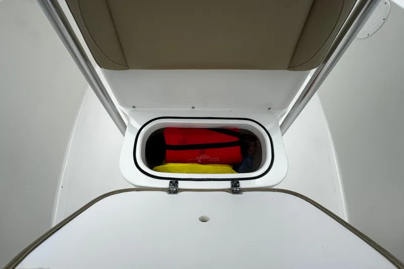 Slide: The Image of Storage compartment on 2019 NauticStar 22 XS Offshore boat, containing life jackets. - 8