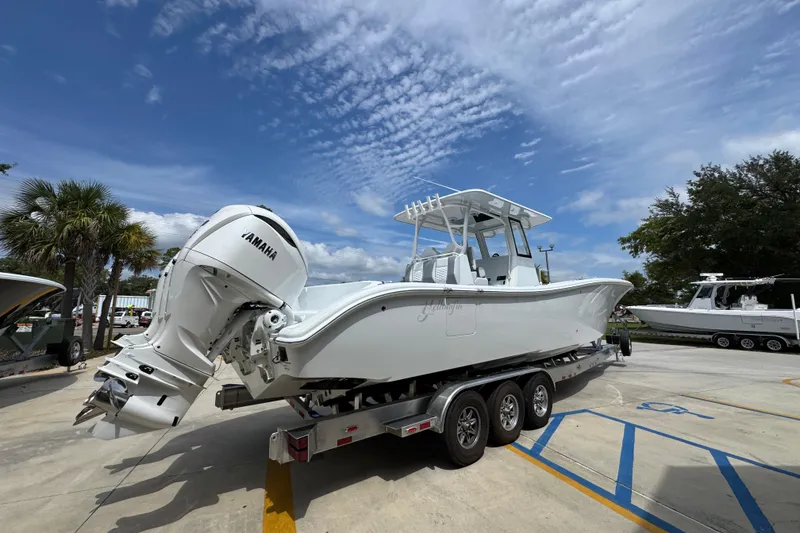 Slide: The Image of 2026 Yellowfin 36 Offshore boat on trailer with Yamaha engines, parked outdoors. - 12