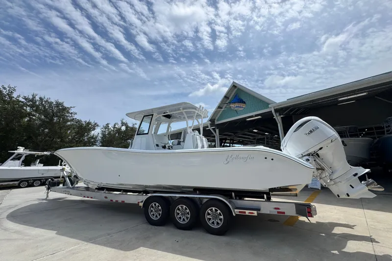 Slide: The Image of 2026 Yellowfin 36 Offshore boat on trailer, parked outdoors under a partly cloudy sky. - 18