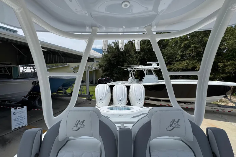 Slide: The Image of 2026 Yellowfin 36 Offshore boat interior with seating and triple engines, displayed outdoors. - 30
