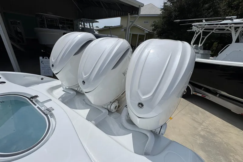Slide: The Image of 2026 Yellowfin 36 Offshore boat with triple outboard engines, docked in a marina. - 44