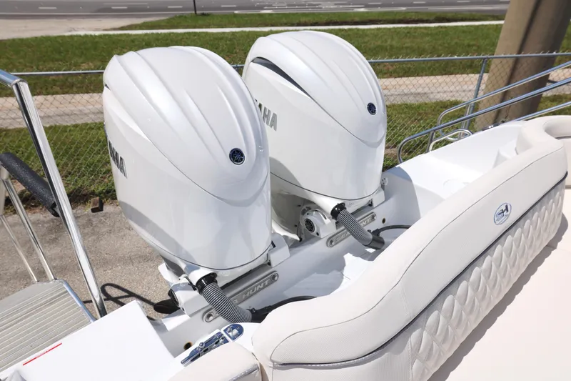 Slide: The Image of 2026 Sea Hunt Ultra 265 SE boat with dual Yamaha 150 engines, docked outdoors. - 10