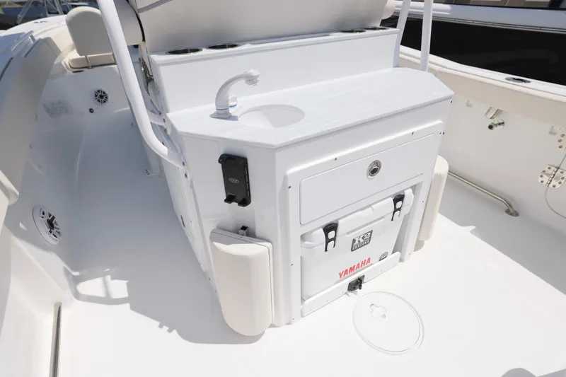 Slide: The Image of 2026 Sea Hunt Ultra 265 SE boat interior, featuring sleek white cabinetry and modern fixtures. - 13