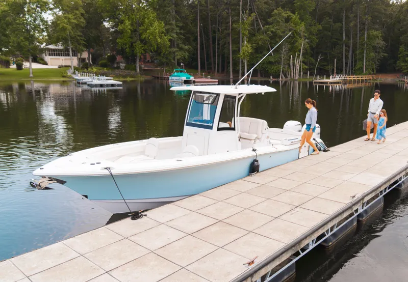 Slide: The Image of 2025 Sea Hunt Ultra 265 SE boat docked near waterfront restaurant and marina. - 37
