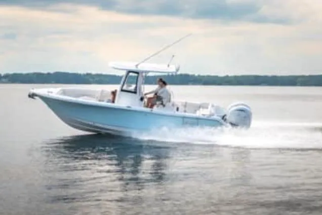 Slide: The Image of 2025 Sea Hunt Ultra 265 SE boat on calm water near trees, Castaway Marine logo visible. - 40