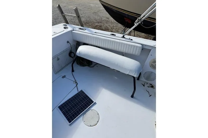 Slide: The Image of 1999 Pro-Line 24 Walkaround boat interior with seating and solar panel. - 13