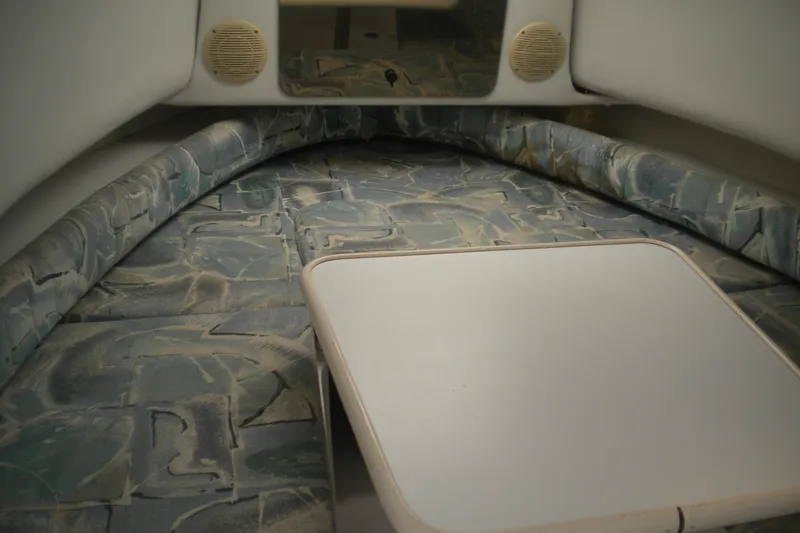 Slide: The Image of 1999 Pro-Line 24 Walkaround cabin interior with patterned seating and table. - 15