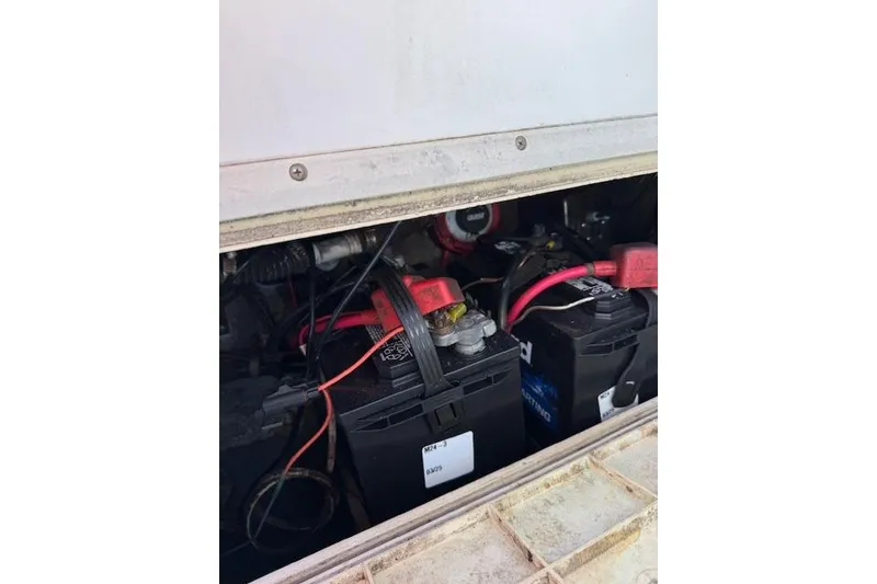 Slide: The Image of Batteries inside a 1999 Pro-Line 24 Walkaround boat, showing wiring and connections. - 19