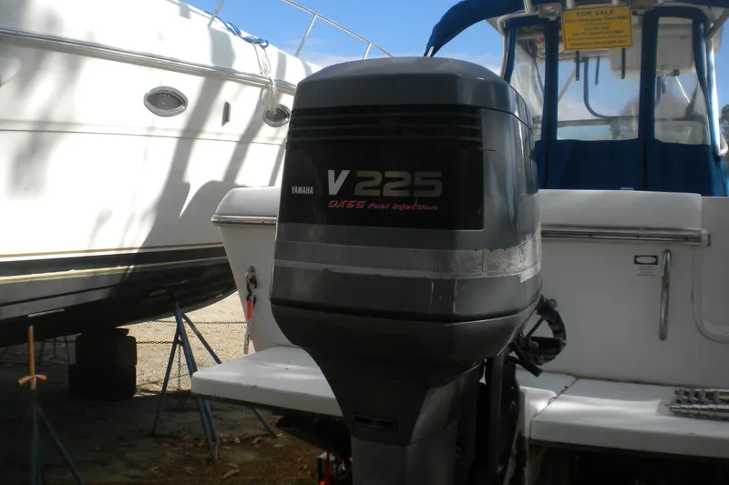 Slide: The Image of 1999 Pro-Line 24 Walkaround with Yamaha V225 outboard motor, parked on land. - 21