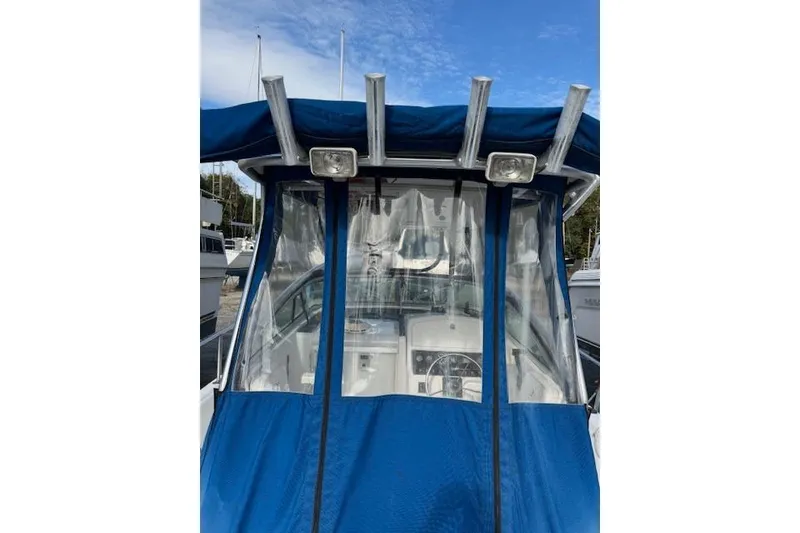 Slide: The Image of 1999 Pro-Line 24 Walkaround boat with blue canopy and clear windshield. - 9