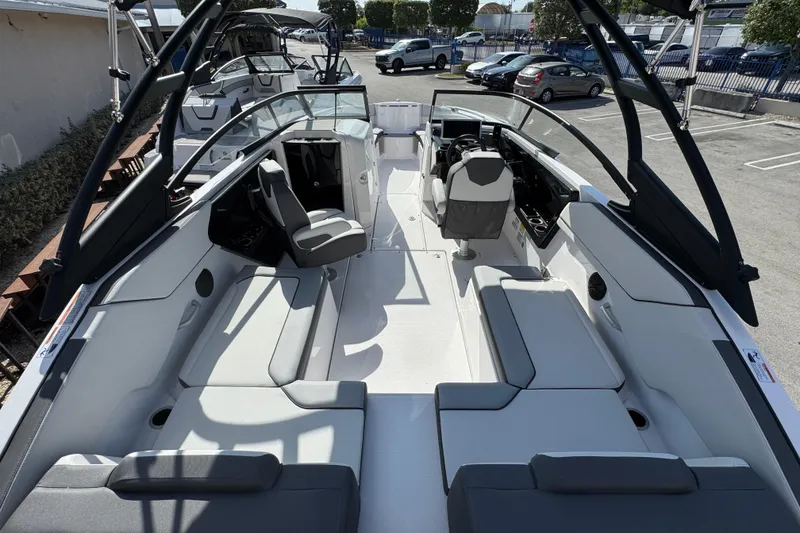 Slide: The Image of 2025 Yamaha Boats AR250 interior with sleek seating and modern design in a parking lot. - 4