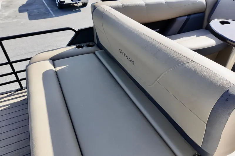 Slide: The Image of 2026 Sylvan Mirage X3 CLZ boat interior with beige seating and cup holders. - 4