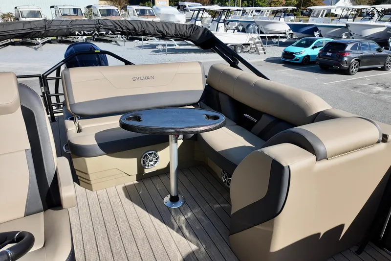 Slide: The Image of 2026 Sylvan Mirage X3 CLZ pontoon boat interior with beige seating and round table. - 8