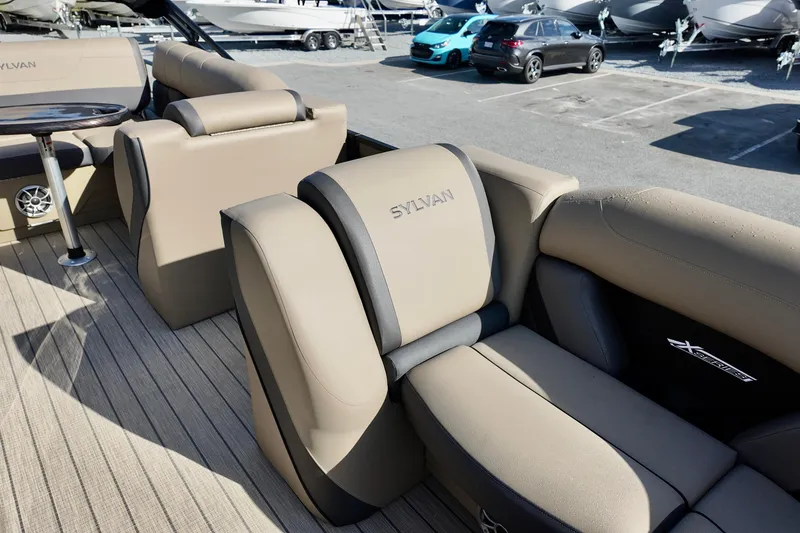 Slide: The Image of Luxurious seating on 2026 Sylvan Mirage X3 CLZ pontoon boat, parked near other vehicles. - 9