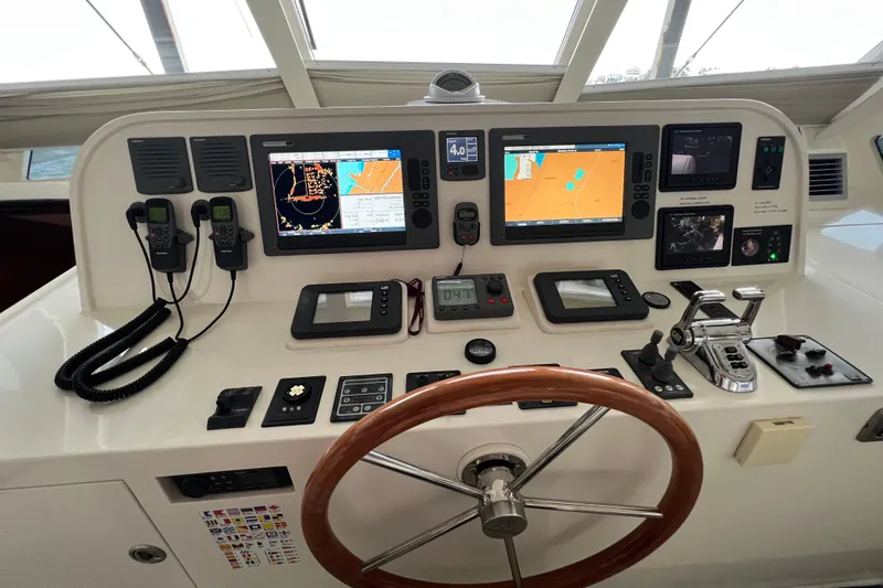 Slide: The Image of Control panel of a 2012 Hampton motor yacht with navigation screens and steering wheel. - 34