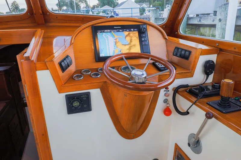 Slide: The Image of 1999 Hinckley Picnic Boat 36 Classic interior with wooden accents and beige seating. - 7