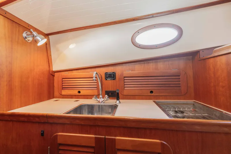 Slide: The Image of Hinckley Picnic Boat 36 Classic 1999 helm with wooden steering wheel and navigation system. - 8