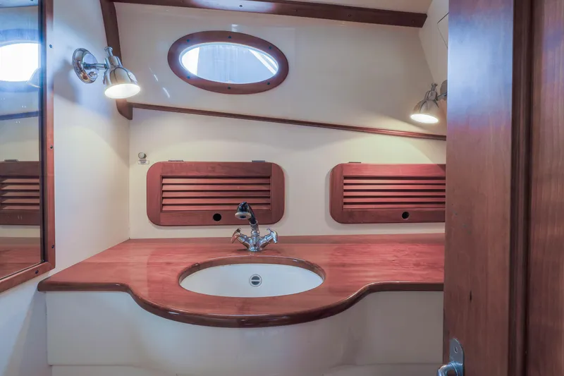 Slide: The Image of Interior of 1999 Hinckley Picnic Boat 36 Classic, featuring a wooden galley with sink and stove. - 9