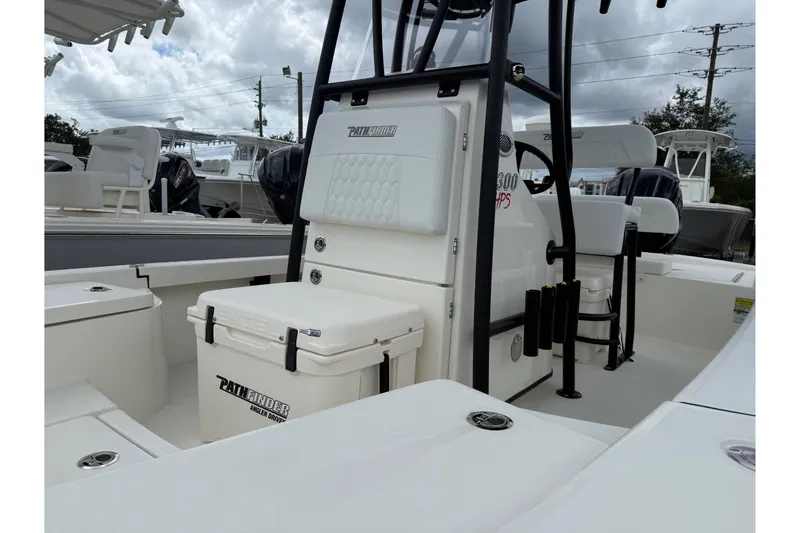 Slide: The Image of 2026 Pathfinder 2300 HPS boat interior with seating and storage, under cloudy sky. - 6